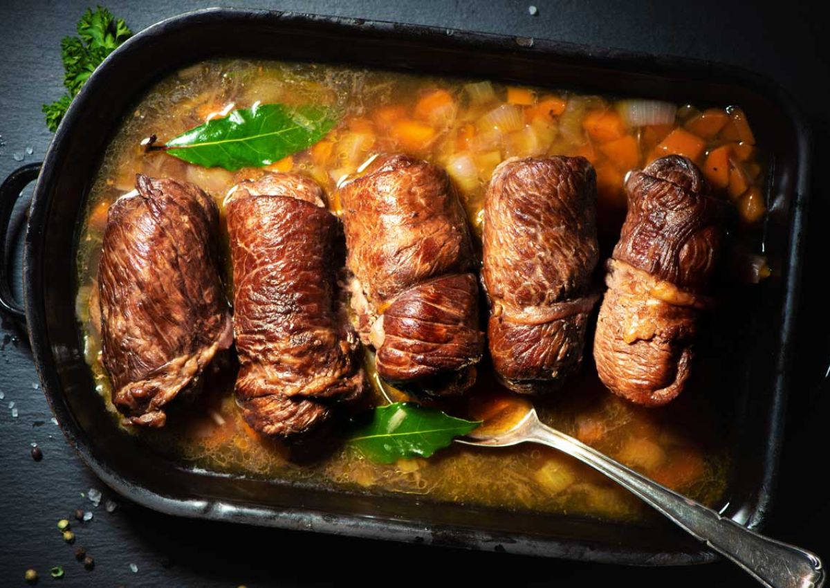Pfanne mit fuenf braungebratenenen Rouladen in Gemuesebruehe